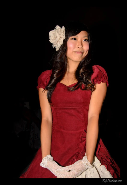 a beautiful young woman posing for the camera in a red dress