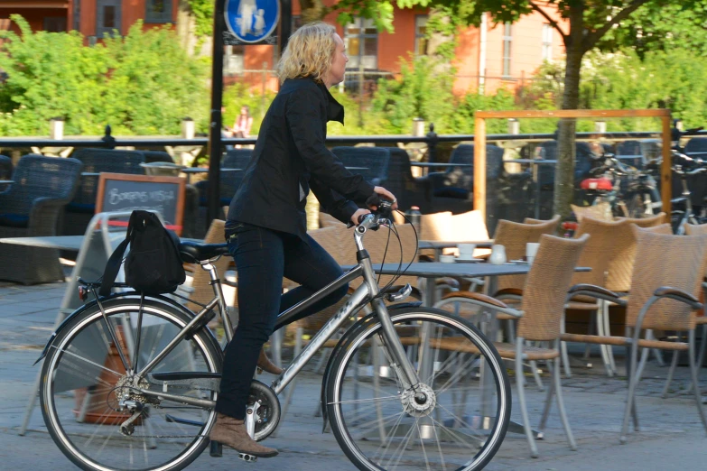 a lady riding a bike down the street