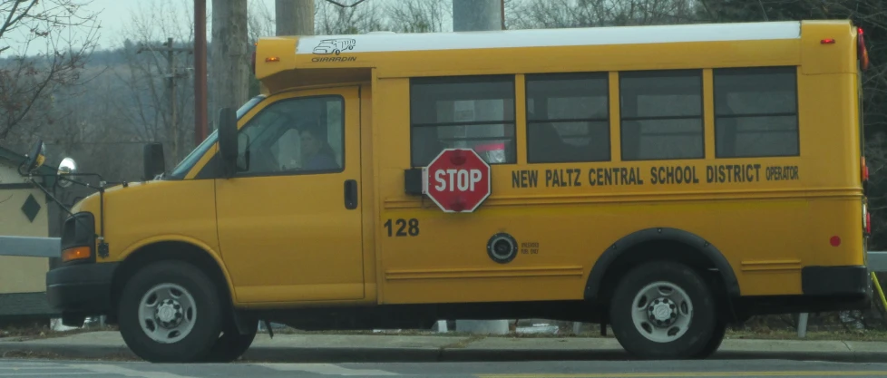 the front view of a yellow bus that has graffiti on it