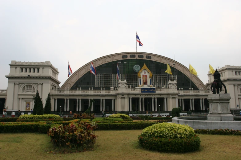 a large building with four flags flying over it's roof