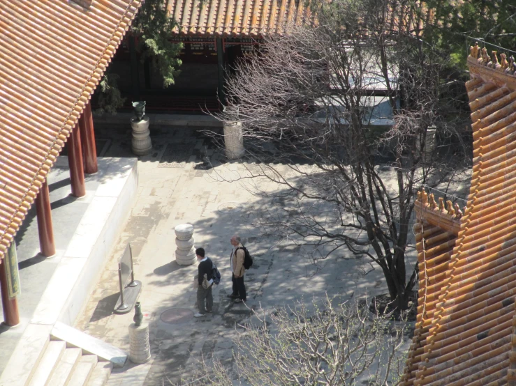 two men are walking next to each other through a courtyard