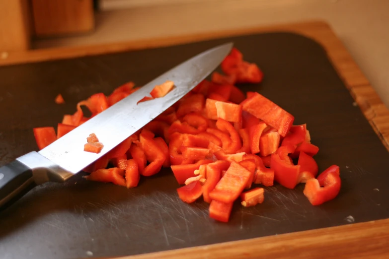 chopped carrots on a  board, with a knife