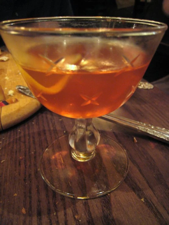 a glass full of liquid on a wooden table