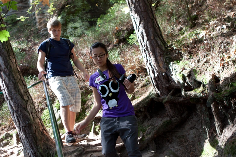 two young people are taking pictures with their phones