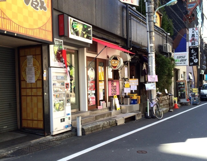 a shop on the corner of the street with advertits outside