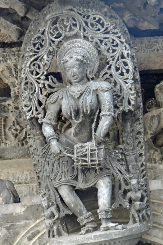 a statue with the image of a god with flowers, on a wall