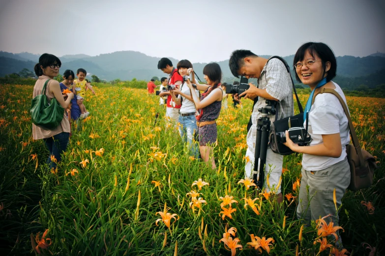people standing in a flower field with a camera