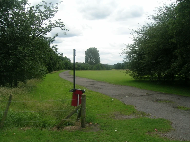 a red bucket in the middle of a lush green field