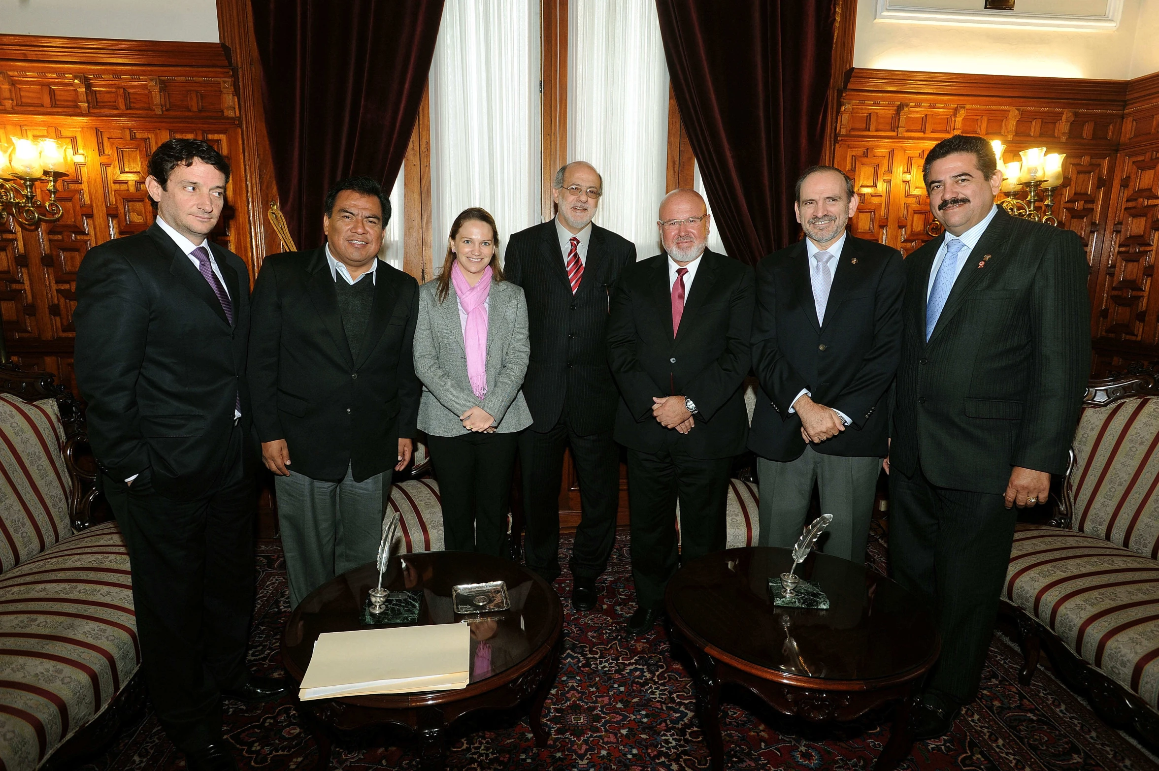 a bunch of people standing near one another in suits and ties