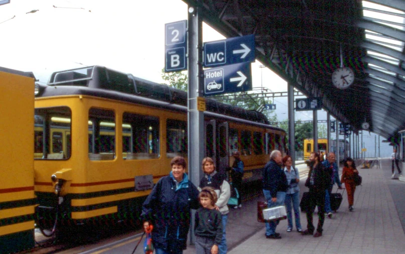 a group of people walking toward a train