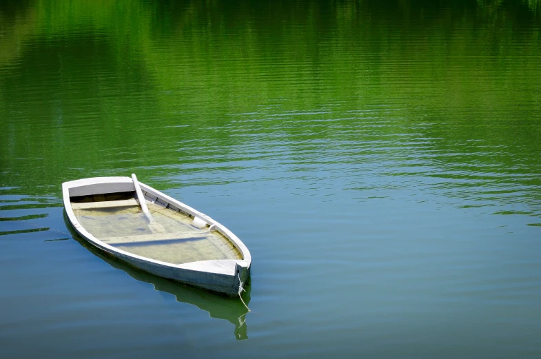 a small boat sitting in the middle of water
