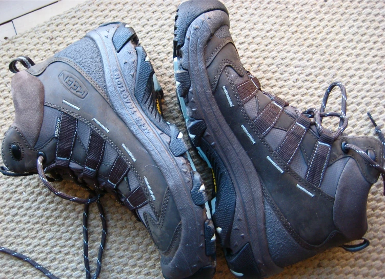 a pair of hike boots with laces hanging from them