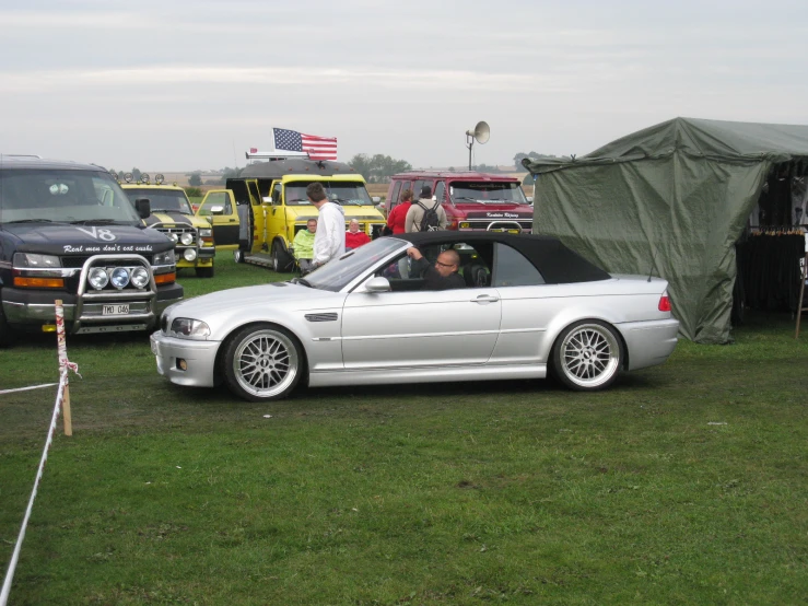 a bunch of cars in a field near some grass