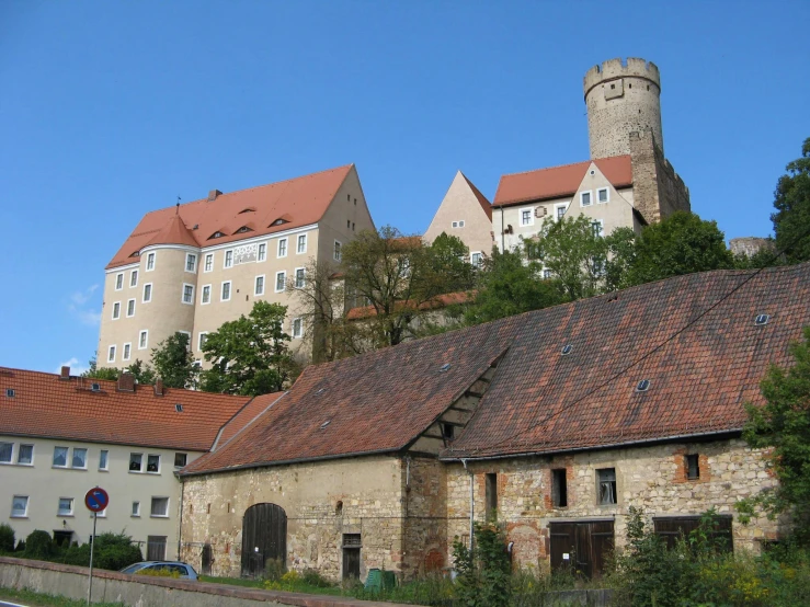 a building on the side of the street with an old tower behind it