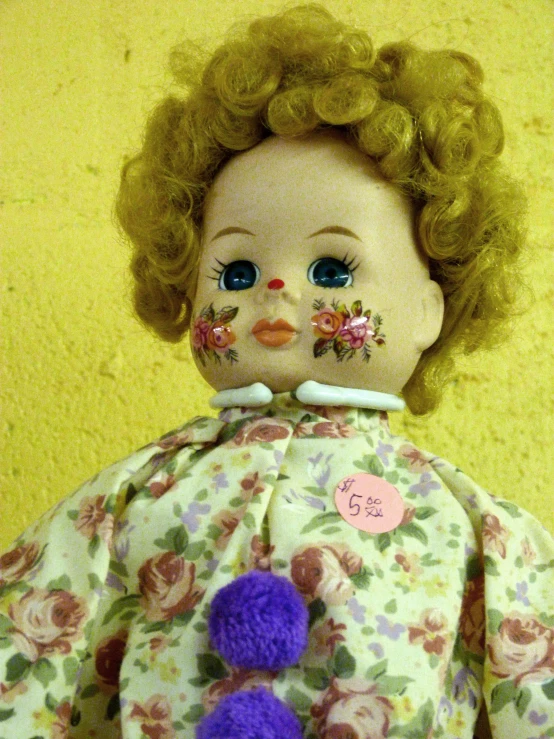 a doll with blue eyes and pink flowers on it