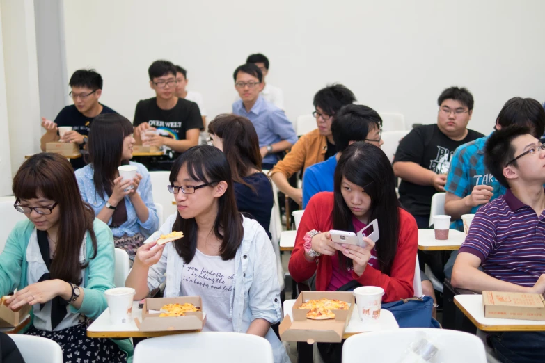 several people sitting down and eating food together