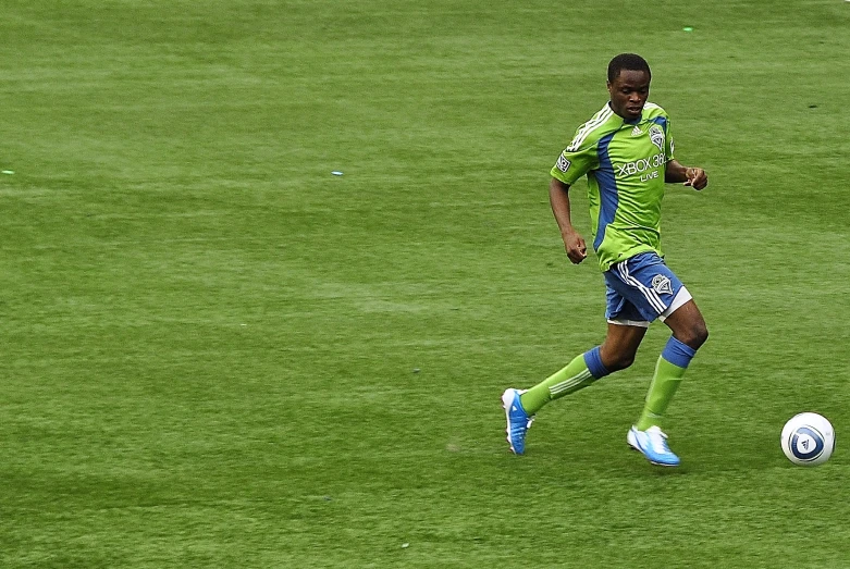 a man on a soccer field kicking a soccer ball