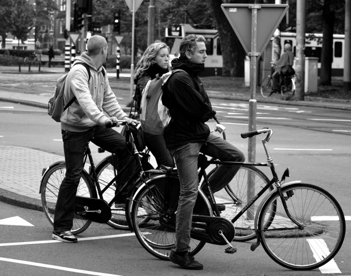 two people on bicycles at an intersection with a traffic light