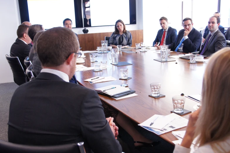 some people sitting at a large table with books