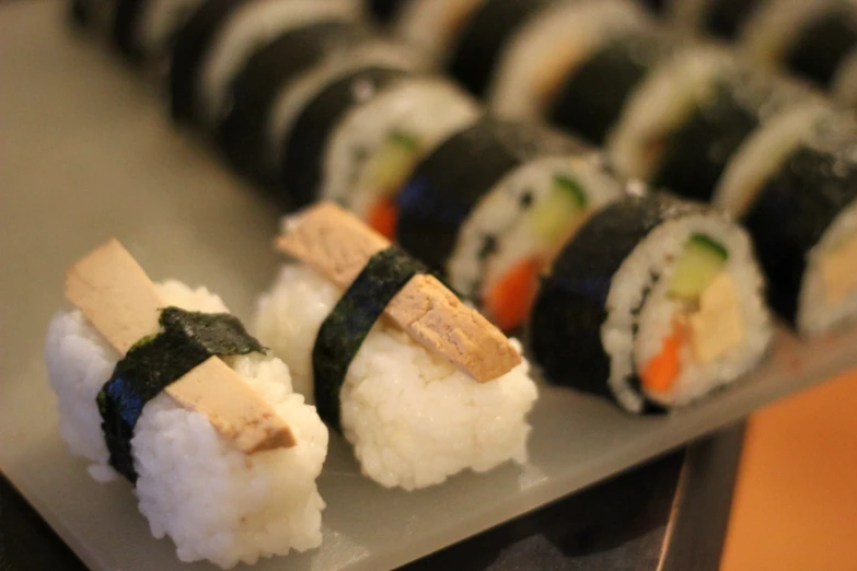several pieces of sushi are displayed with sticks