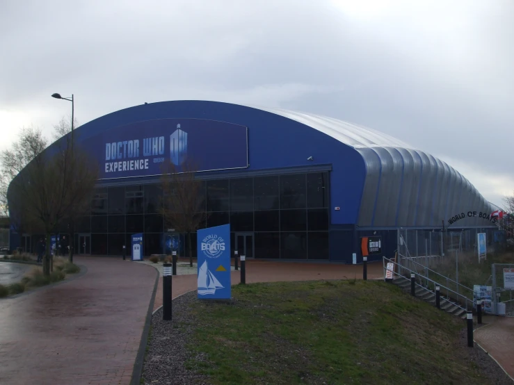 there is a giant blue building with signs in front