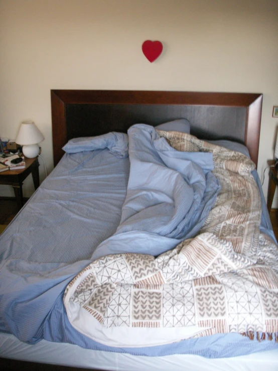 a bed with a heart shaped pillow on top of it