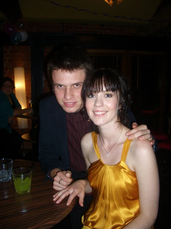 two people posing for a po while at a table