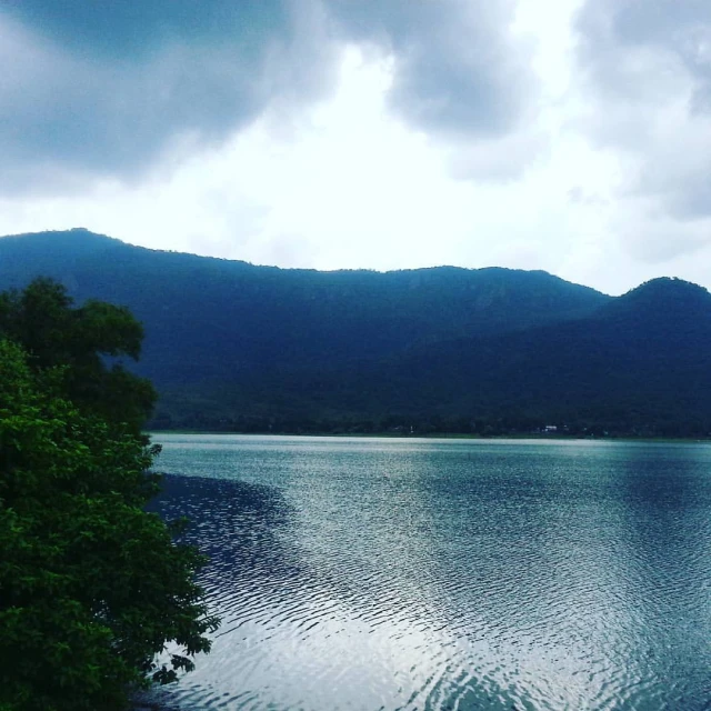 a lake surrounded by mountains with trees and water