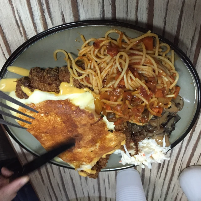 a plate full of spaghetti and hash browns