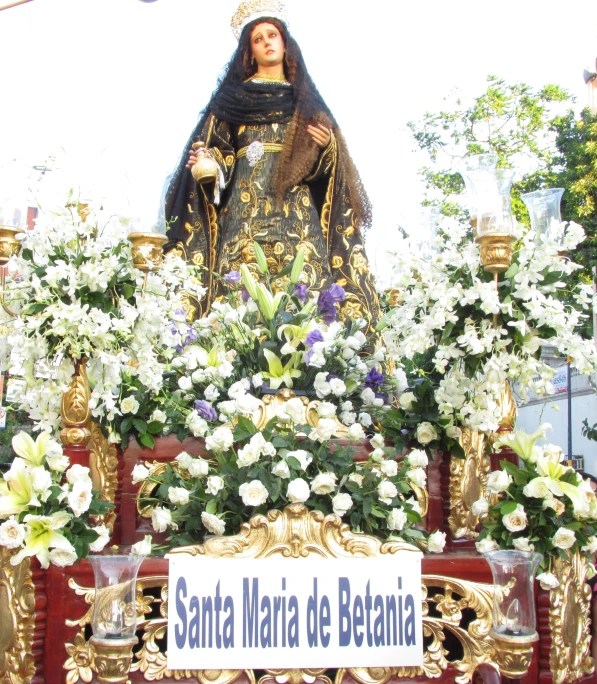 a statue of the virgin mary in front of some flowers