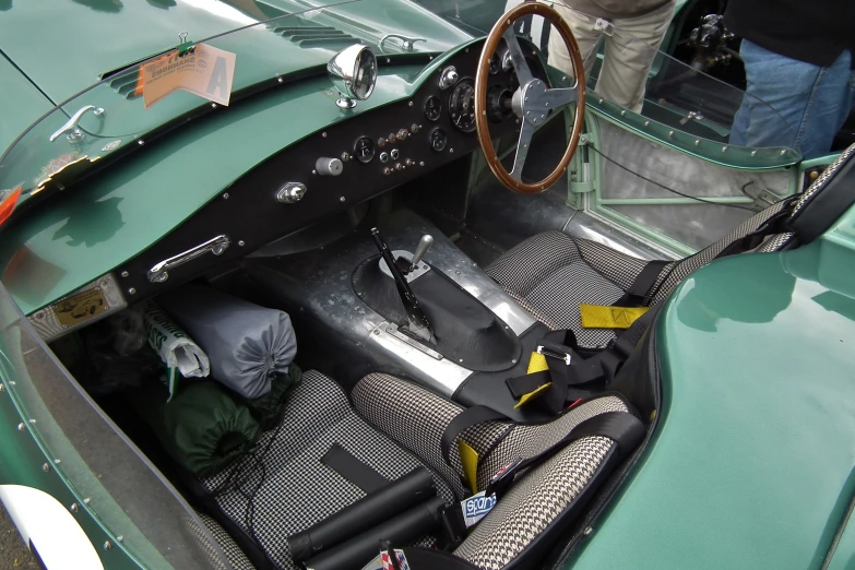 a vintage car sits with a small amount of luggage