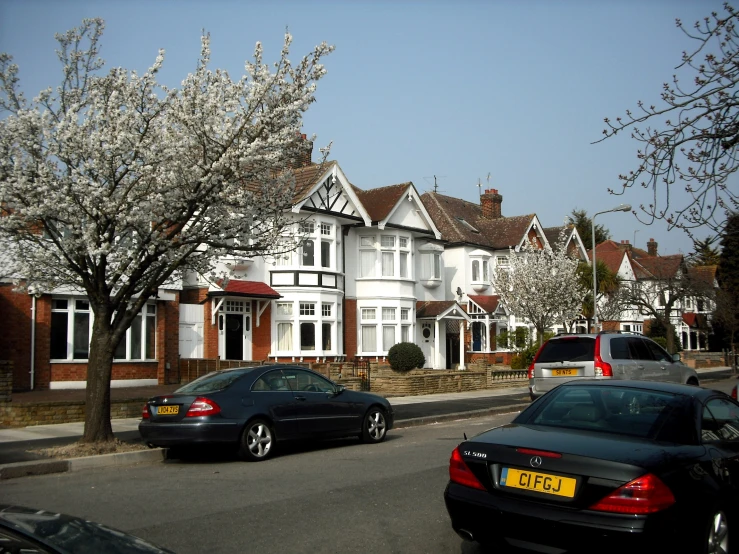 cars parked along side of a home on the road