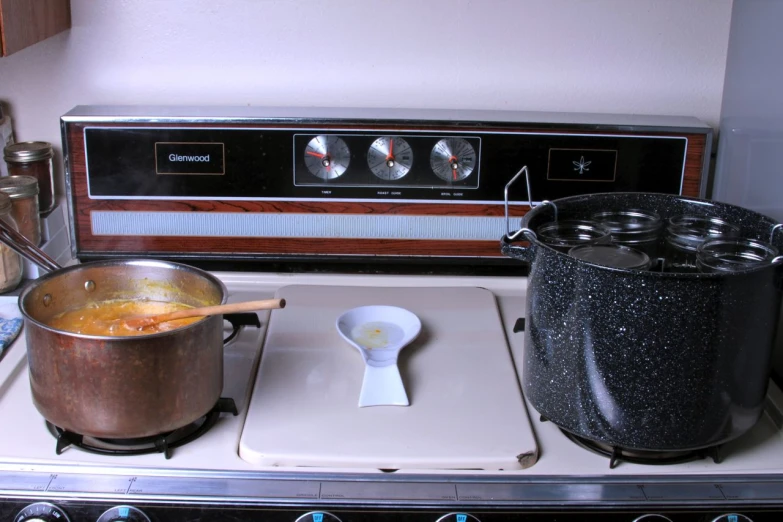 a metal pot sits on the burner in front of a stove