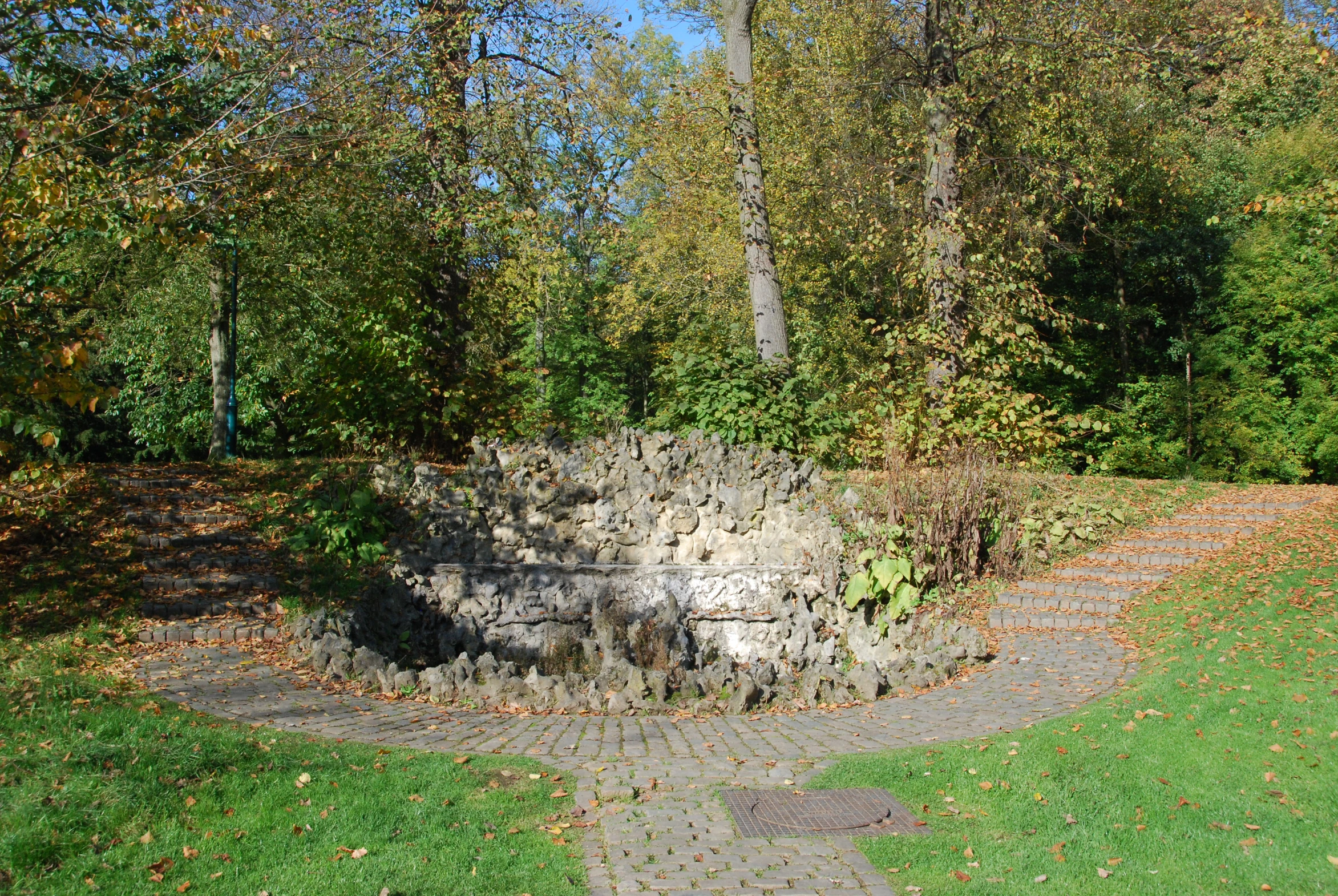 an area with a stone bench and trees