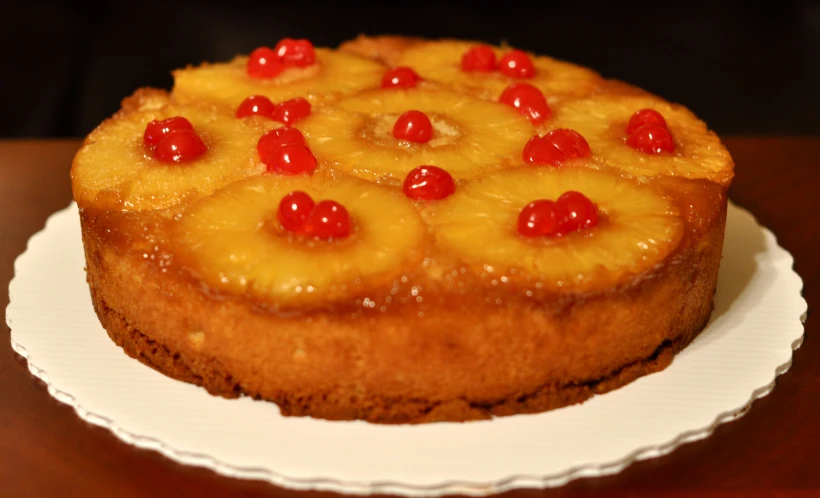 a cake sitting on a plate topped with pineapple slices