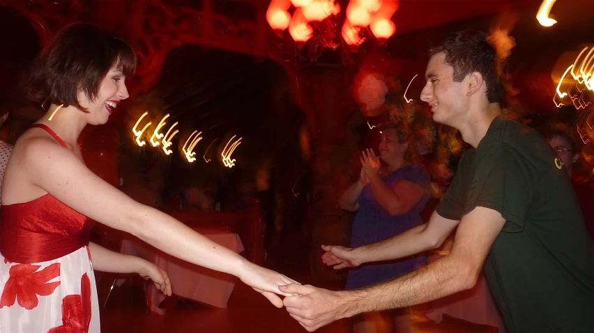 the couple is holding hands while dancing together