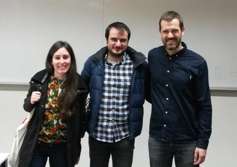 three people standing in a room smiling at the camera