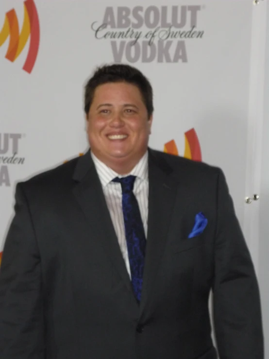 a man smiles for a picture in a suit