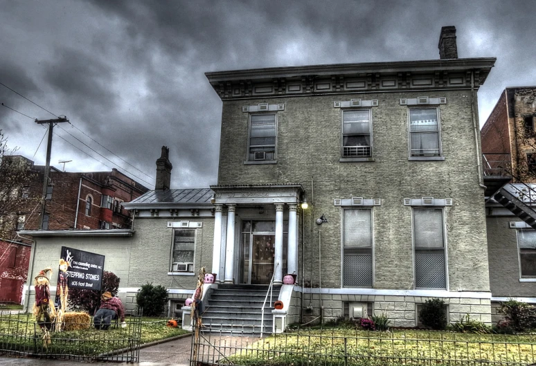 this is an old two story house with a cloudy background