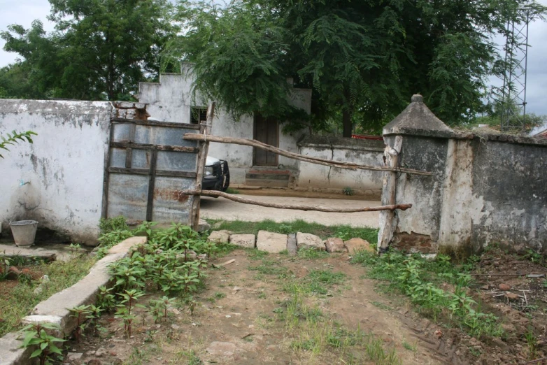 an old and broken gated in building next to trees