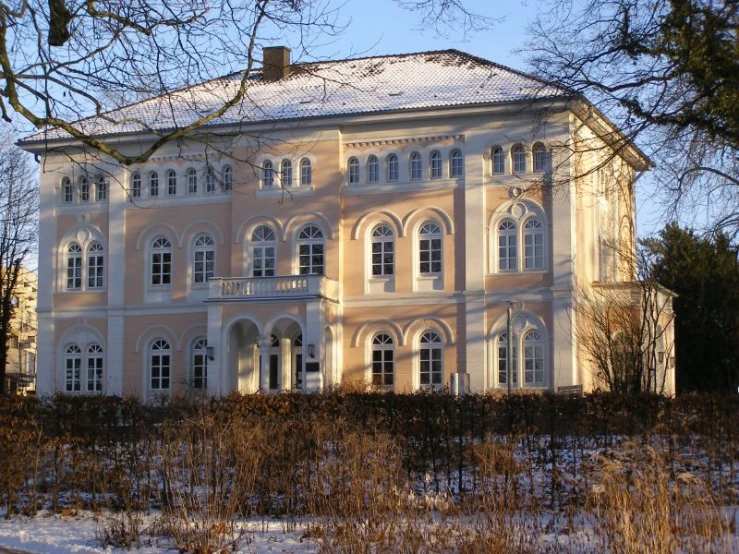 a large white house is shown in winter