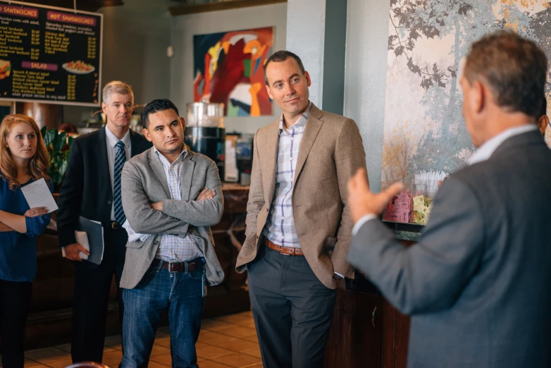 a group of business people gather at a table in a cafe