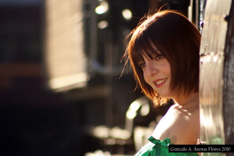 woman in green shirt standing by metal fence