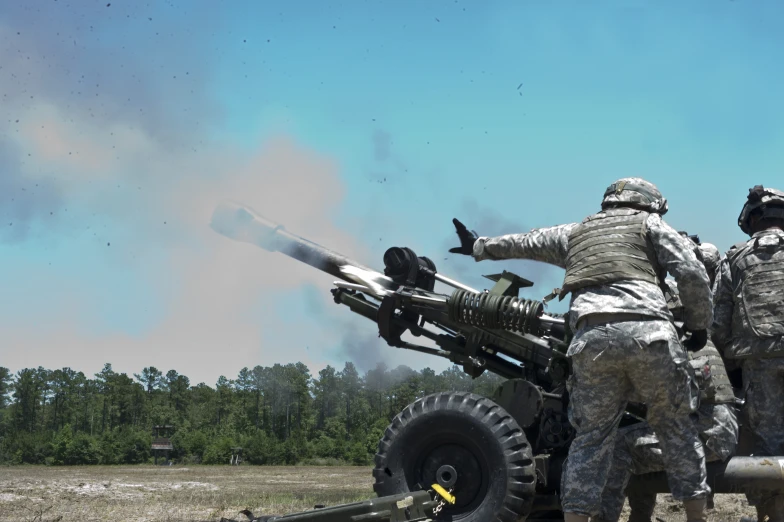 three men in military fatigues on an open field