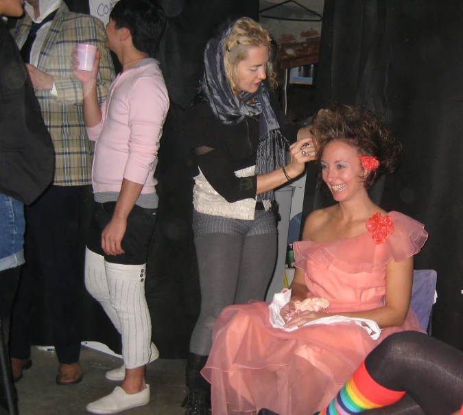 a woman is shaving another woman's hair