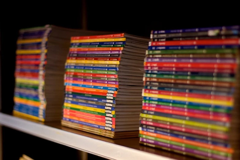 stacks of books sitting on top of a white shelf