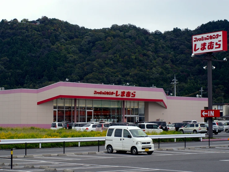 cars are parked outside the front of a shopping center