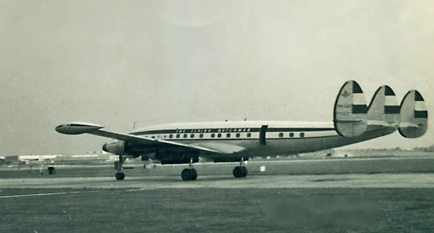 an old airplane sitting on the tarmac at an airport