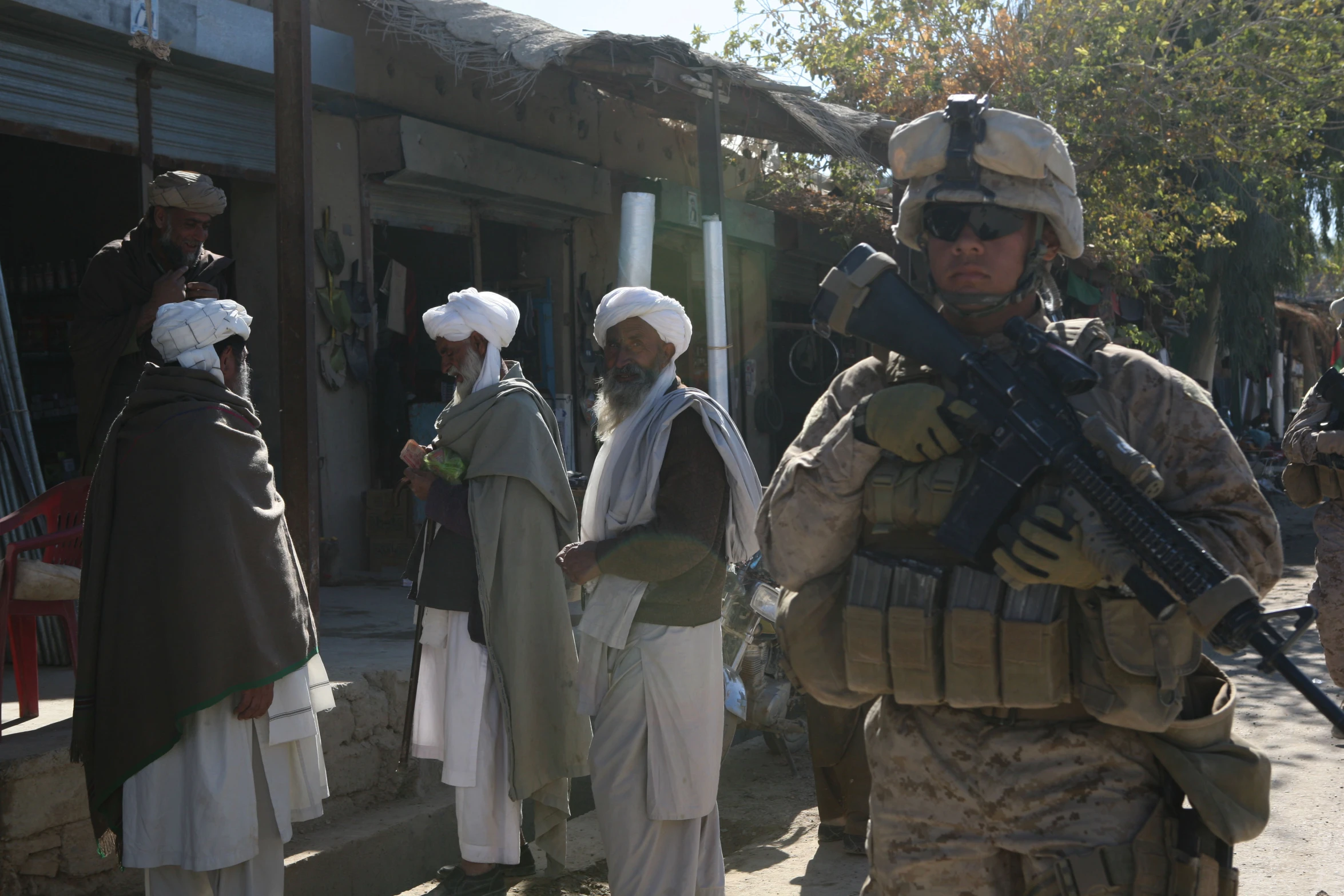 men in uniforms with rifles stand in the street