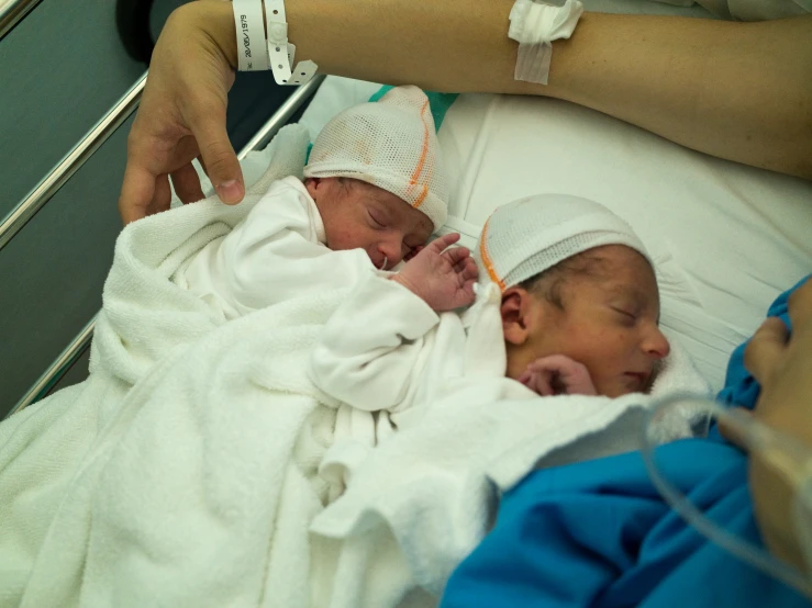 a nurse checking on the oxygen drips of two newborn babies